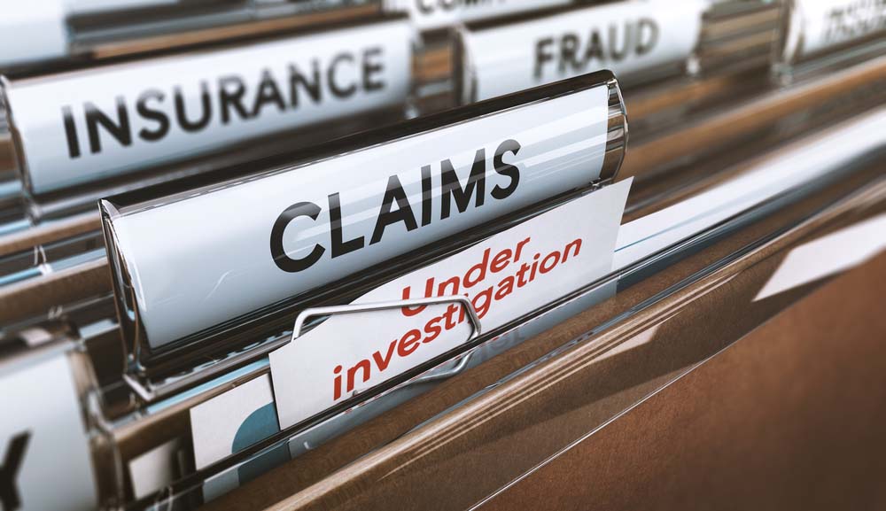 olders labeled “Water Damage Claims” on a desk